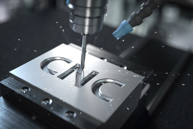 A CNC machine milling detailed curved features into a white workpiece